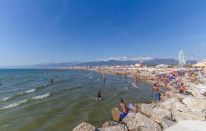 a group of people on a beach with people in the water at Stunning Apartment In Viareggio in Viareggio