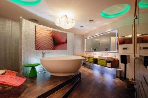 ein Badezimmer mit einer großen Badewanne und einem großen Spiegel in der Unterkunft Hotel Berlin, Berlin, a member of Radisson Individuals in Berlin