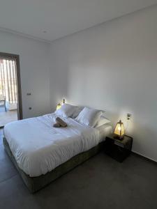 a bedroom with a large bed with white sheets at Terrasses, soleil & confort à 3 min de la mer ! in Essaouira