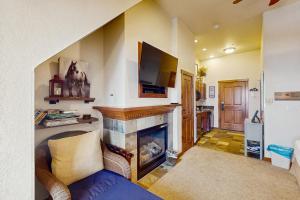 a living room with a fireplace and a tv at Main Street Station in Breckenridge