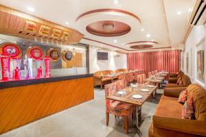 a restaurant with tables and couches and a bar at Hotel Highway Greens Near VR Punjab Mall Airport Road Mohali Chandigarh in Mohali