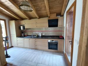 a kitchen with wooden cabinets and a stove top oven at Le chalet des oliviers in Vézénobres +20 photos