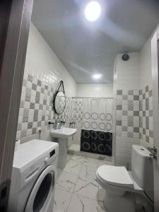 y baño con lavamanos y lavadora. en SWEET APARTMENT RUSTABELi, en Kutaisi