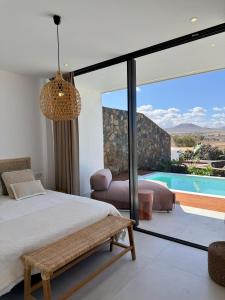 a bedroom with a bed and a pool at Villa Lima by Aura Collection in La Oliva