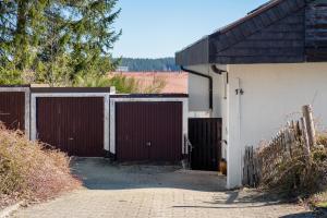 a garage with two gates on the side of a house at Ferienwohnung Victoria in Schonwald im Schwarzwald