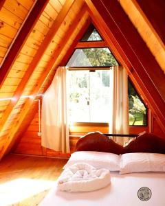 a person laying on a bed in a room with a window at Recanto dos Xaxins in São Francisco de Paula