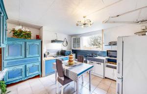una cucina con mobili blu e un tavolo con sedie di 1 Bedroom Amazing Apartment In Treignac a Treignac