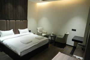 una camera da letto con un letto, un tavolo e delle sedie di Hotel The Royalista a Bathinda Altre 10 foto
