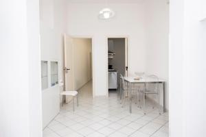 une pièce blanche avec une table et des chaises et une cuisine dans l'établissement Appartamento Eva a due Passi dal Mare, à San Vito Lo Capo