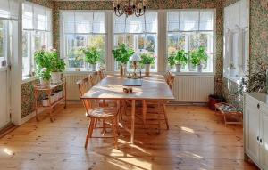 a dining room with a table and chairs and windows at Nice Home In Ljusterö With Sauna in Norra Ljustero