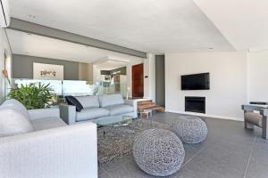 a living room with a couch and chairs and a tv at Valtameri by Totalstay in Cape Town