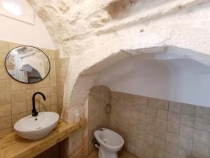 a bathroom with a sink and a toilet at Minuetto 73 in Ostuni