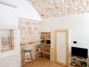a living room with two chairs and a television at Minuetto 73 in Ostuni