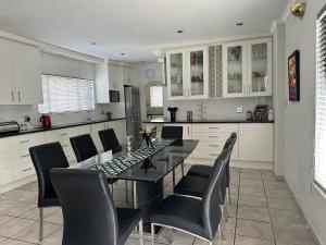 a dining room with a table and chairs in a kitchen at AfriSky guest house in Kempton Park