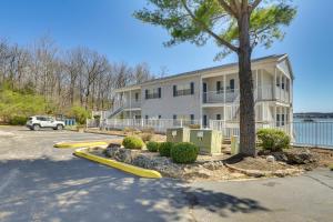 a large white building with a tree in front of it at Waterfront Condo with Pool on Lake of the Ozarks in Lake Ozark