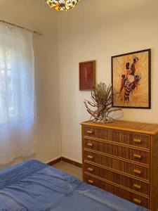 a bedroom with a dresser and a bed at Le Tre Ghinee in Tropea