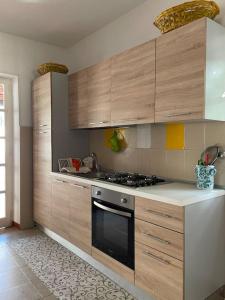 a kitchen with wooden cabinets and a stove top oven at Le Tre Ghinee in Tropea