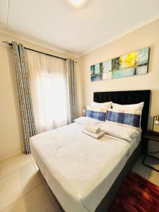 a bedroom with a large white bed with a window at Classy 1 bed in Midrand at 93 on New Estate in Midrand +82 photos