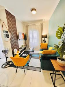 a living room with a green couch and yellow chairs at Classy 1 bed in Midrand at 93 on New Estate in Midrand