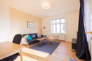 a living room with a couch and a table at Central Lyngby Apartments in Kongens Lyngby