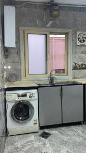 eine Küche mit Waschmaschine und Spüle in der Unterkunft relax newcairo in Kairo
