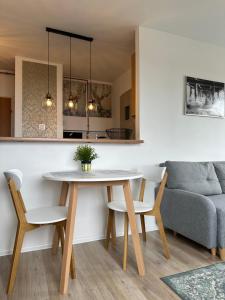 a dining room with a table and a couch at Panorama Bałtyku in Sopot