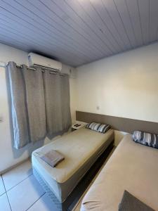 a bedroom with two beds and a ceiling at Villa Germânia - Pousada da Luiza in Santa Cruz do Sul +9 photos