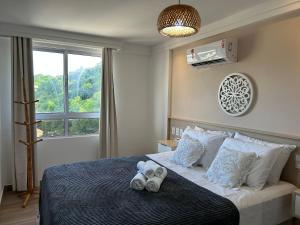 a bedroom with a bed with two pairs of shoes on it at Bela Hospedagem - Puerto Ventura, frente mar e ao lado do food park in João Pessoa +45 photos