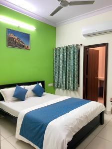 Un dormitorio con una cama grande con una pared verde. en Hotel Rajasthali, en Jodhpur