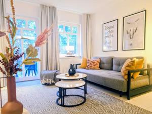 ein Wohnzimmer mit einer Couch und einem Tisch in der Unterkunft Ferienwohnung Lieblingssuite am Strand in Ahlbeck