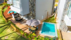 an overhead view of a house with a pool and an umbrella at Naluum Residence - Paraíso Pé na Areia em Milagres com Conforto e Lazer! in Passo de Camarajibe