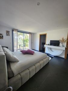 a bedroom with a large bed and a fireplace at Villa l’écrin du Rayol in Rayol-Canadel-sur-Mer +17 photos
