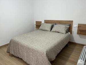 una camera da letto con letto, testiera e cuscini in legno di La casa del abuelo José a Las Eras
