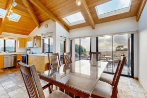 a dining room with a table and some windows at Blue Heron in Sea Ranch