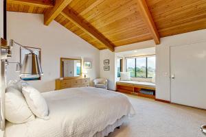 a bedroom with a white bed and a window at Blue Heron in Sea Ranch +23 photos
