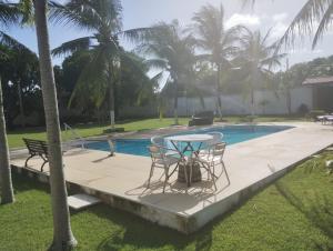 a table and chairs next to a swimming pool at Tabuleiro Beach in Aquiraz