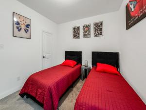2 bedden in een kamer met een rood dekbed bij Retro Living! in Lewisville