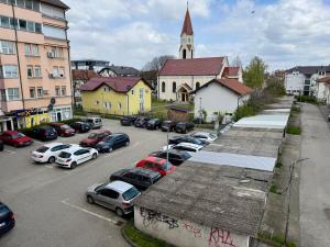 a parking lot with cars parked in front of a church at Andjelka apartman in Modriča
