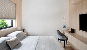 a bedroom with a bed and a chair and a television at Santa Justa Bedrooms in Lisbon