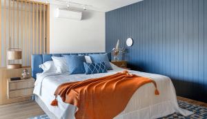a bedroom with a bed with an orange blanket on it at Santa Justa Bedrooms in Lisbon