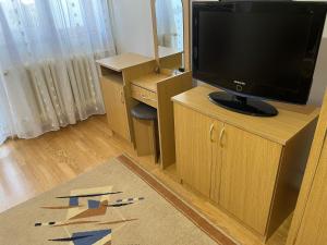 a living room with a television on a wooden cabinet at Garsonieră Brazda lui Novac in Craiova