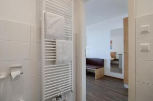ein Bad mit einer Dusche mit einer Bank im Hintergrund in der Unterkunft Gästehaus D i c k r e i t e r in Immenstaad am Bodensee + 37 Fotos