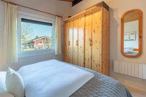 Un dormitorio con una cama blanca y una ventana. en Deichblick, en Simonsberg