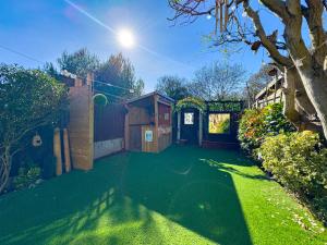a yard with a green lawn with a shed at Basildon Retreat Cozy 3-Bedroom Home in Basildon