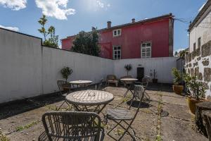 un patio avec des tables et des chaises et un bâtiment rouge dans l'établissement GuestReady - Charming House Marquês, à Porto