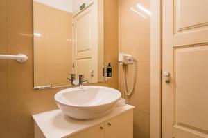 une salle de bain avec un lavabo blanc et un miroir dans l'établissement GuestReady - Charming House Marquês, à Porto