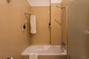 une baignoire dans une salle de bain avec douche dans l'établissement GuestReady - Charming House Marquês, à Porto 105 autres photos