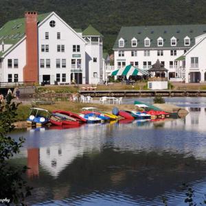 a group of boats sitting in the water near buildings at Snowy Owl Inn in Waterville Valley