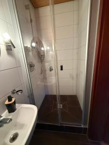 ein Badezimmer mit Dusche und Waschbecken in der Unterkunft Zum Griechen Restaurant und Pension in Forchtenberg