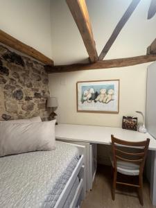 ein Schlafzimmer mit einem Bett und einem Schreibtisch mit Stuhl in der Unterkunft La Casita de Verdiago in Verdiago